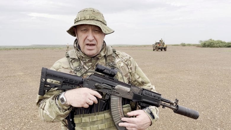 Yevgeny Prigozhin, chief of Russian private mercenary group Wagner, gives an address in camouflage and with a weapon in his hands in a desert area at an unknown location, believed to be in Africa. This image was taken from a video published August 21, 2023.