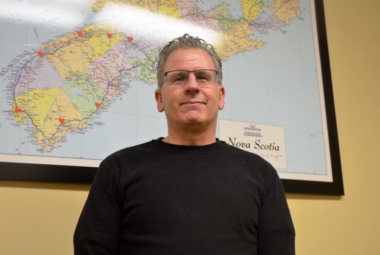 A man stands in front of a map.