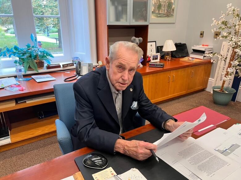 Man sitting at his desk, holding papers