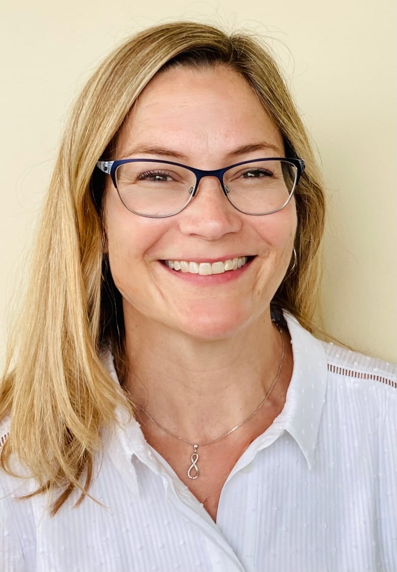 A woman smiles in a close-up photo. 