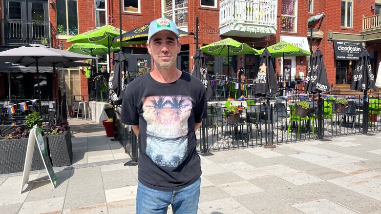 A bar owner stands outside his terrace. 