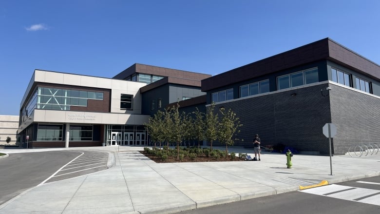 A large new looking building. It is white, brown and black and 'L' shaped. 