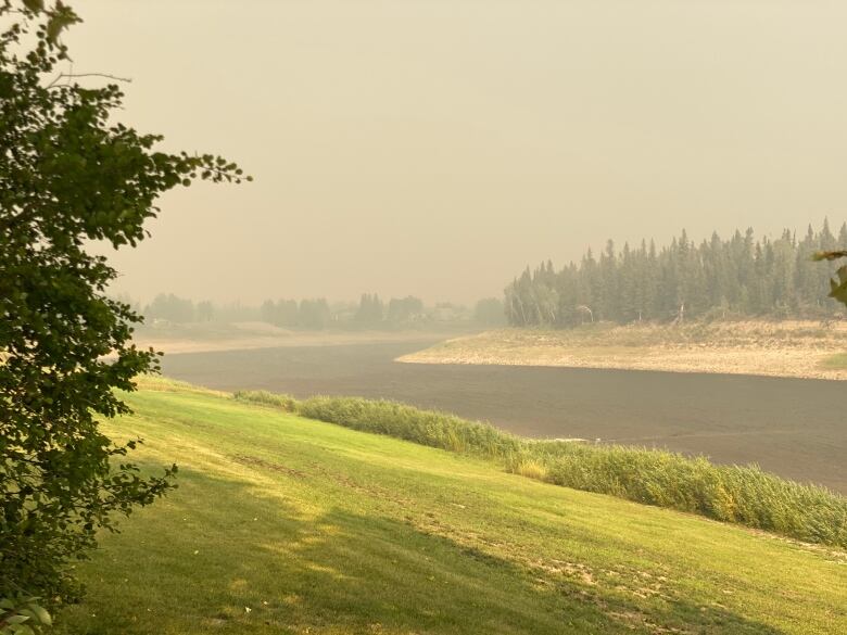 An empty road with haze and smoke visible in the background.