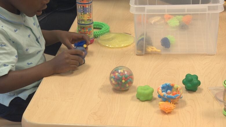 A boy is playing with toys at a table in a day care centre.