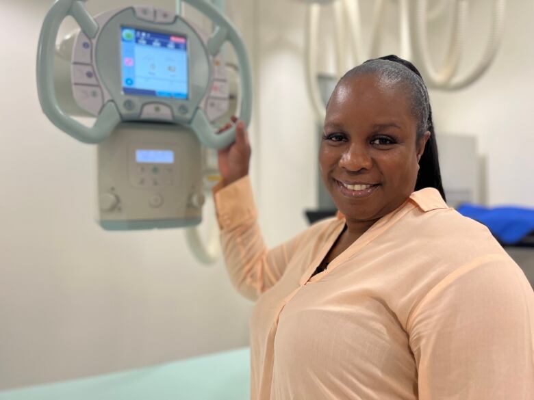 Jennifer Julien holding a part of an x-ray machine.