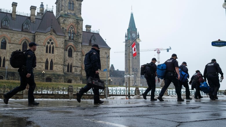 RCMP officers make their way to a bus as they head off Parliament Hill, in Ottawa, before the visit by U.S. President Joe Biden to Canada, on Thursday, March 23, 2023. 