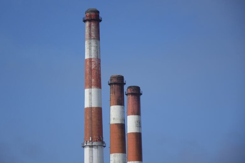 The red and white smokestacks of the Holyrood thermal generating station on a sunny winter day.