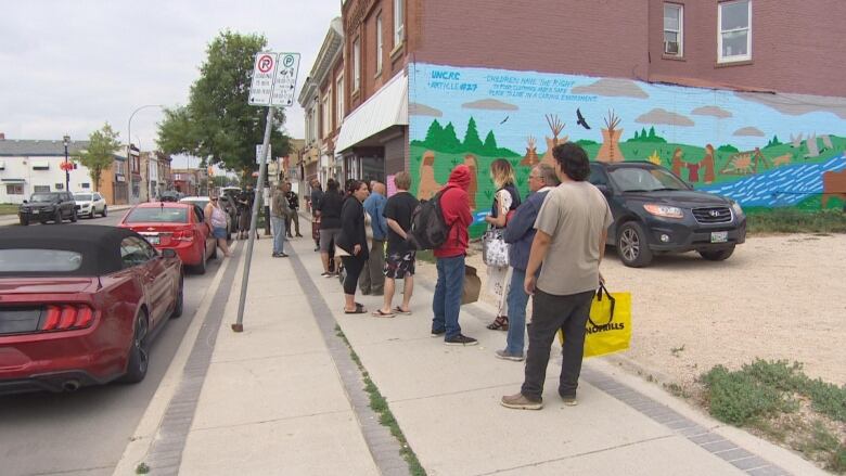 People line up outside the food bank on Selkirk Avenue that has been run by the Bear Clan Patrol up until late last week. The non-profit Community Helpers Unite is filling in for the next while the Bear Clan seeks more funding.