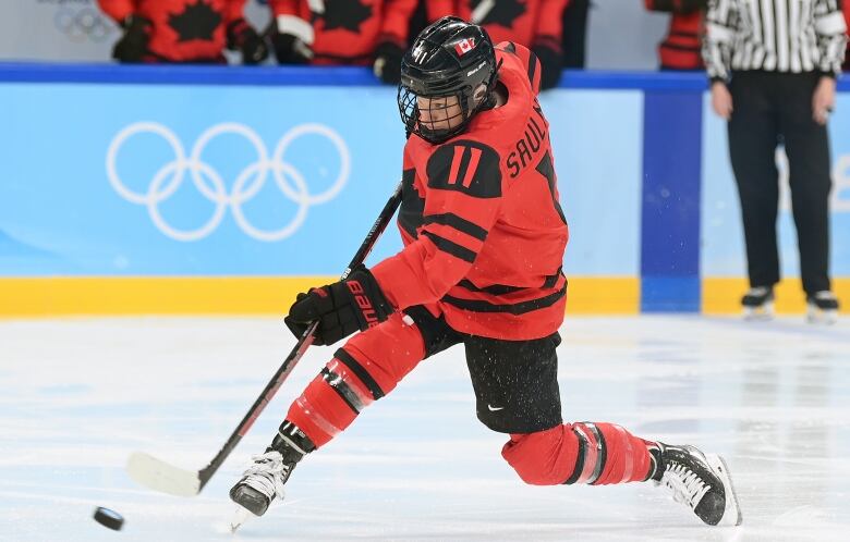 A hockey player shoots the puck.