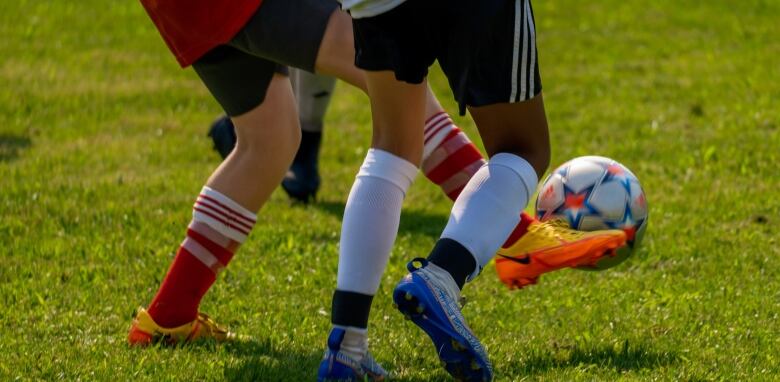 Two players compete for a soccer ball.