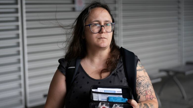 A woman holds a naloxone kit in her hands. 