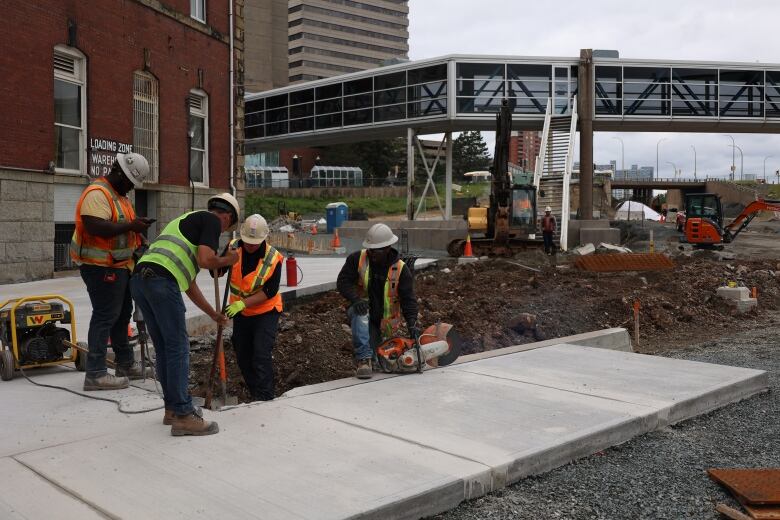 Four construction work to build a sidewalk in Halifax's Cogswell district. 