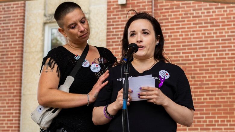 One person comforts a speaker at a drug overdose awareness walk.