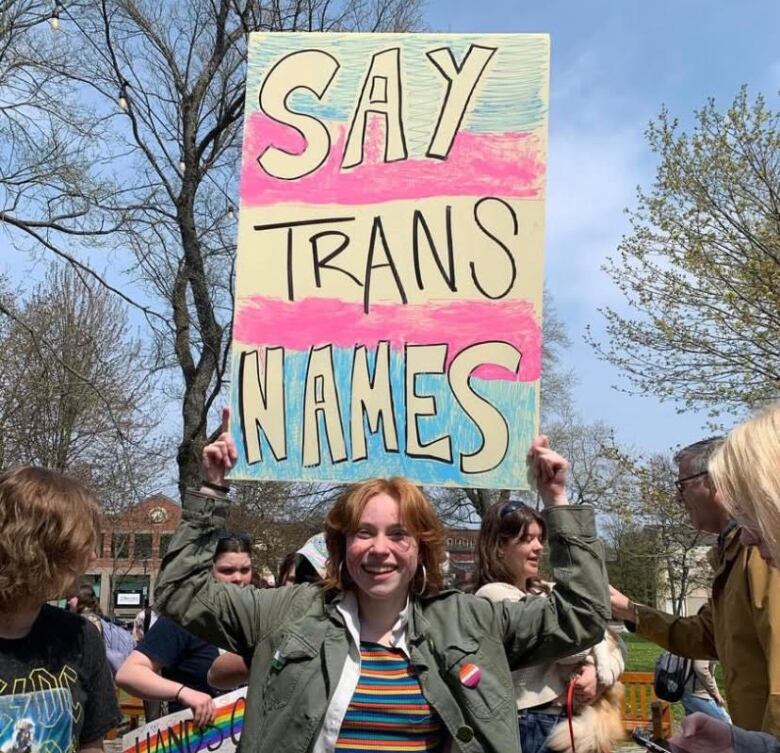 Person holding sign up at protest that reads Say Trans Names