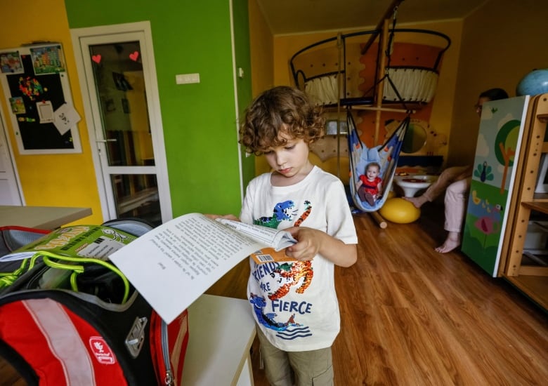 A young student collects his school bag in preparation for the first day of school in Ukraine. 