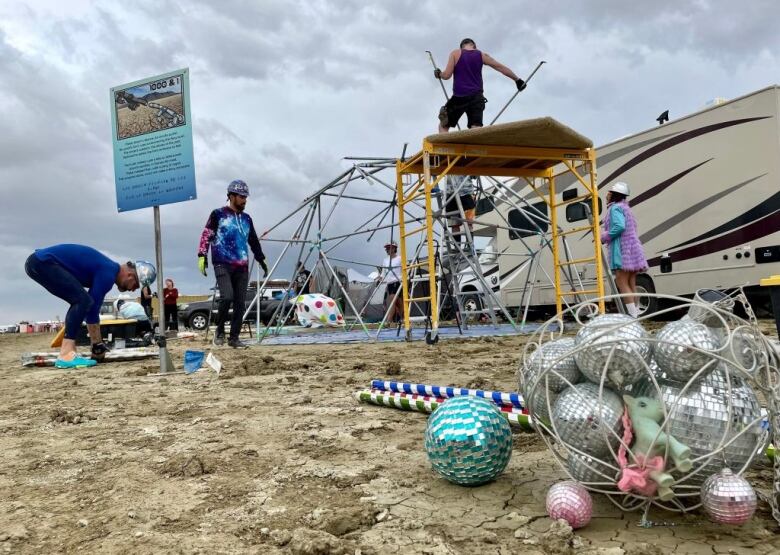 Men disassemble a Burning Man campground in Nevada.