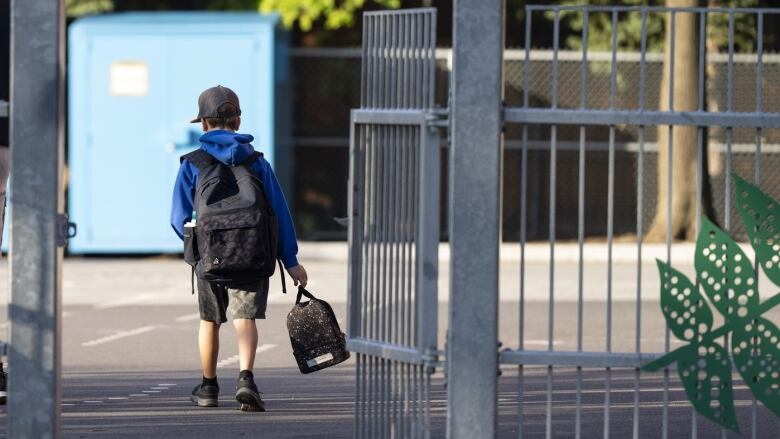 An elementary student arrives for his first day back to school in Montreal, Monday, Aug. 28, 2023. 