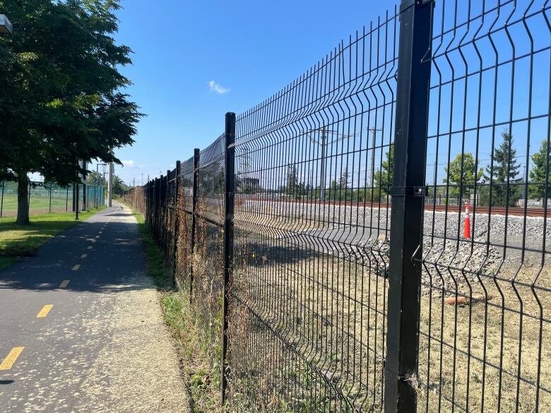 train tracks, fence, bike path