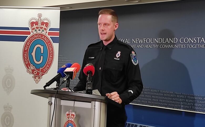 Police officer talking in front of a podium.