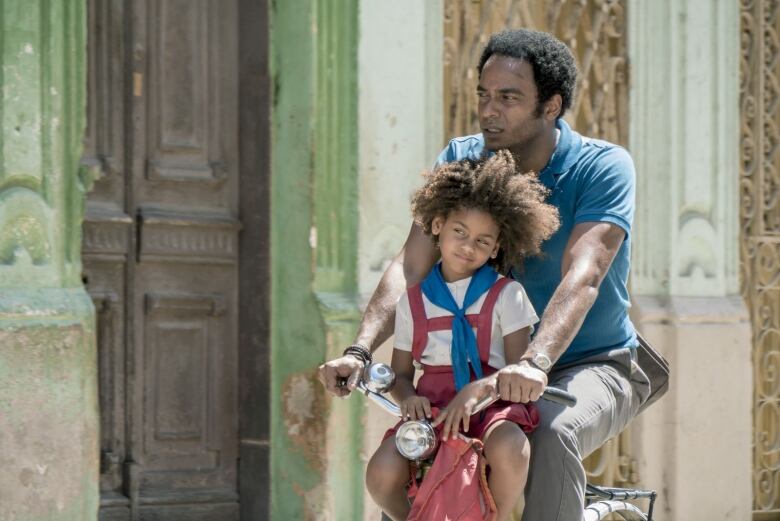 Still frame from the film Sergio and Sergei. Toms Cao and Ana Gloria Budun ride a bicycle together.