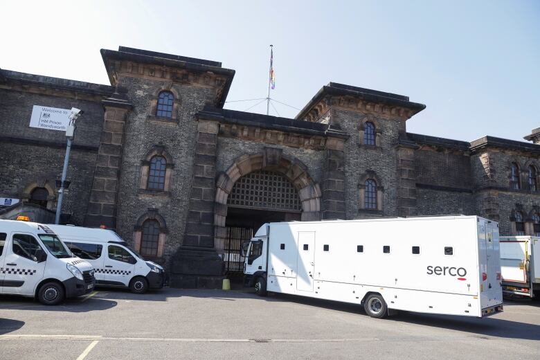 Wandsworth Prison, London, U.K., with police and corrections vehicles parked in front