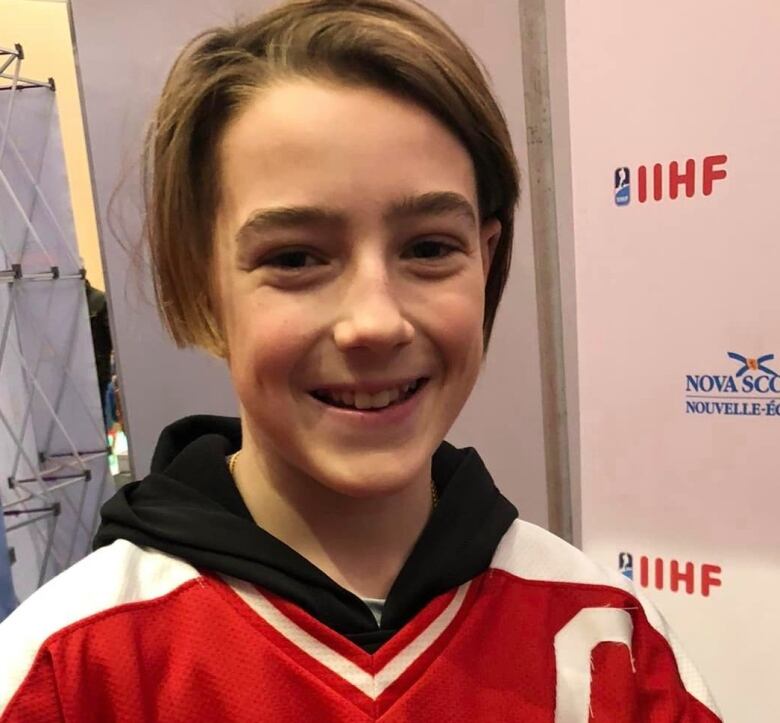 A young boy in a hockey sweater.