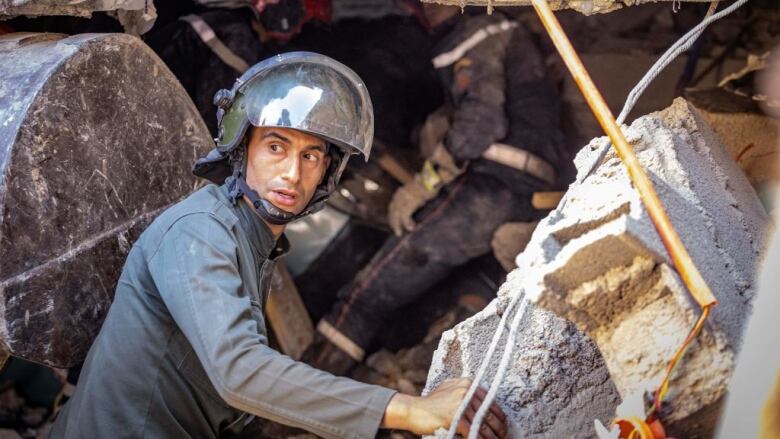 A rescuer looks around at earthquake damage.