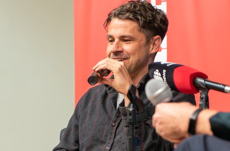 A man speaks into a microphone. 