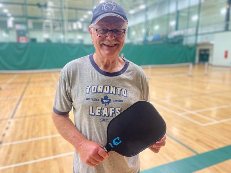 A man holding a pickleball racquet 