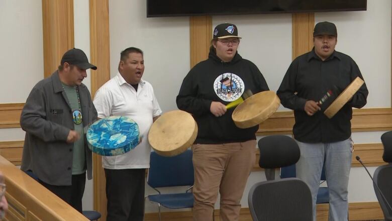 Four people playing drums. 