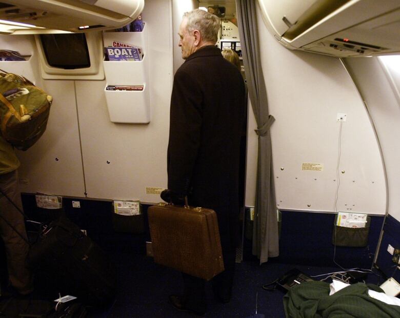 Prime Minister Jean Chretien stands with his briefcase  before exiting the plane following his last foreign trip as leader of the country, Wednesday Dec 10, 2003 in Ottawa Ontario, Canada.