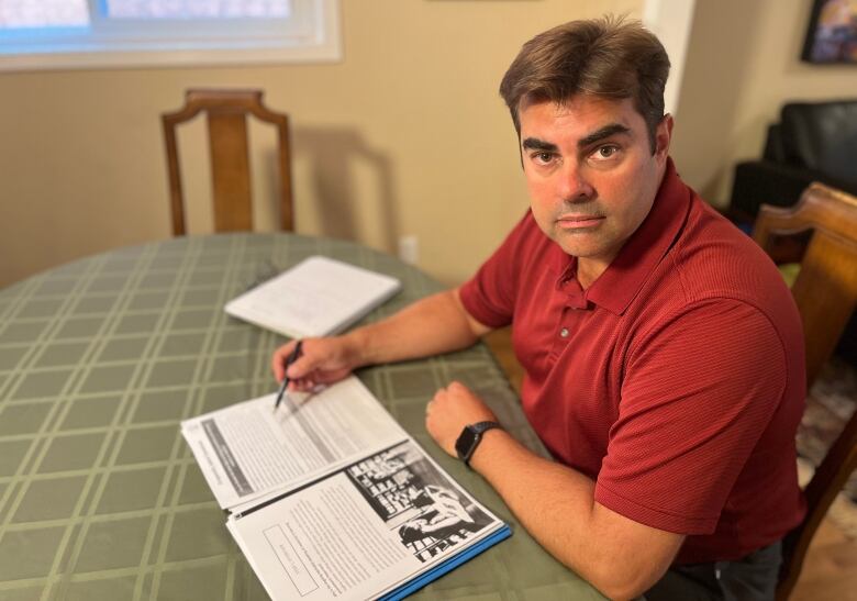 Man sitting at table with documents in front of him.