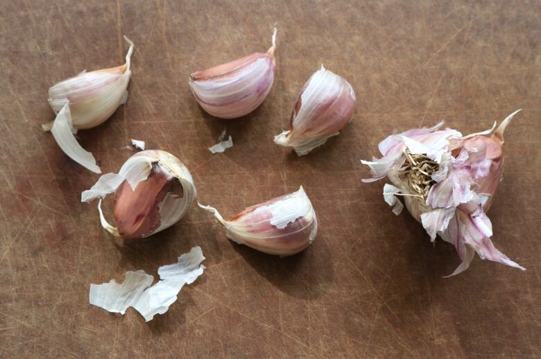 Bits and pieces of garlic bulbs are visible against a dark background.