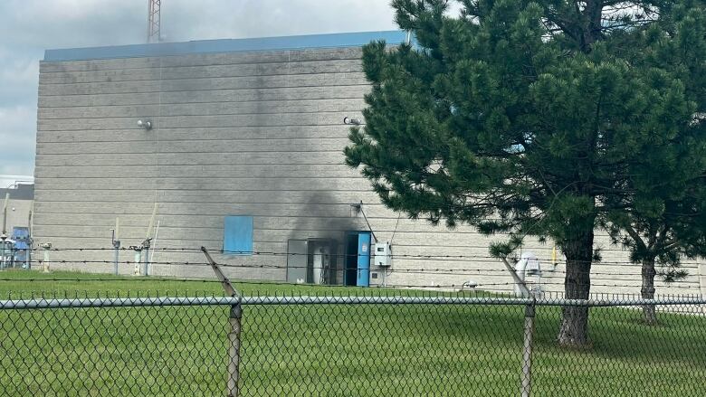 A brick building with smoke coming out of a door way.