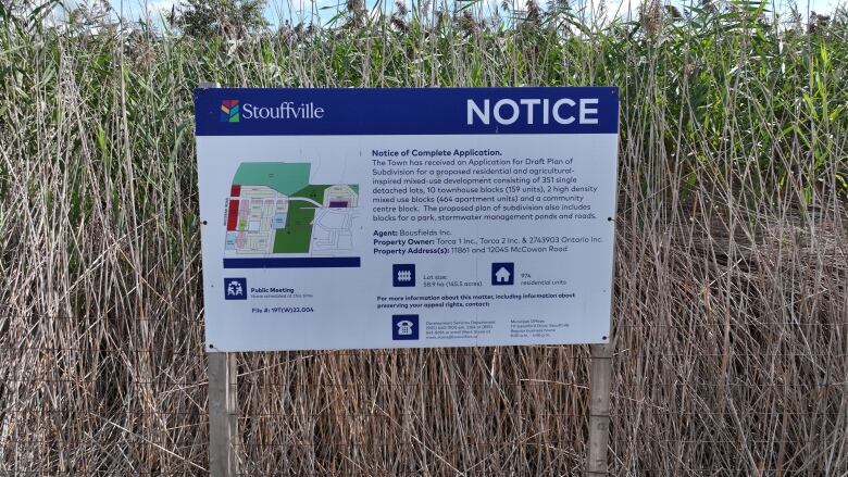 A sign contains information about a proposed development in Stouffville.