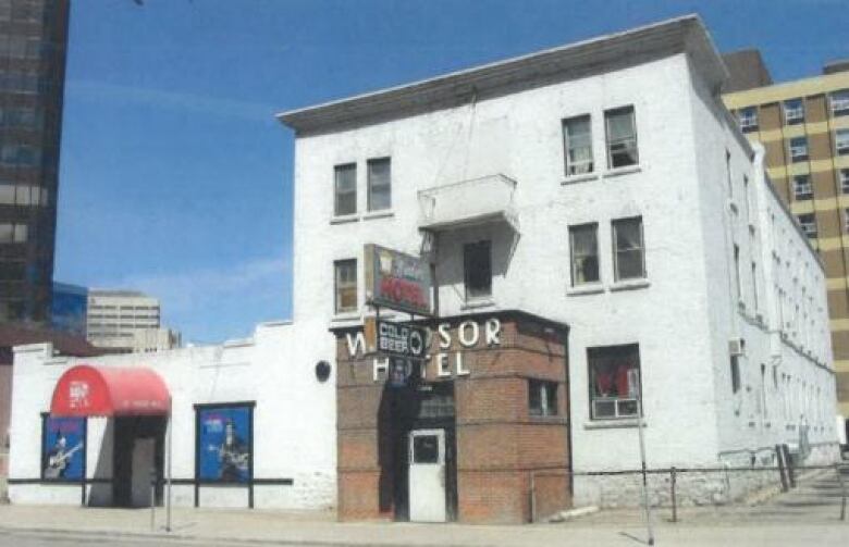 A white building sits along a street.