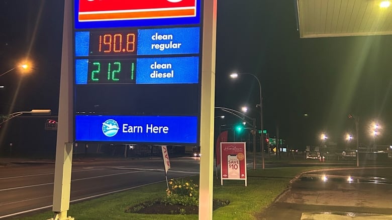 Sign showing price of gas at night.