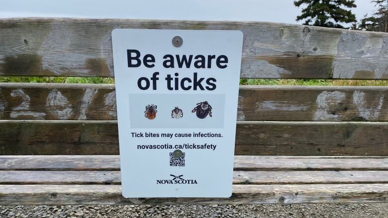 A sign on the back of a bench.