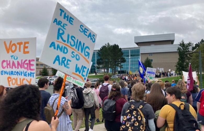 people holding signs and walking.