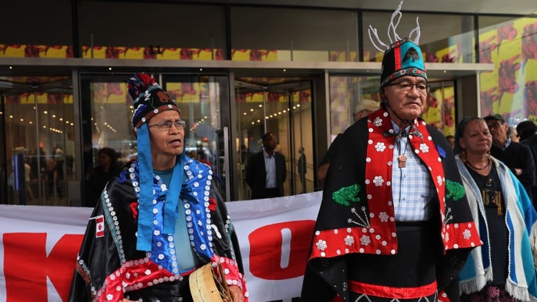 Two Indigenous men participate in a protest in New York City outside the Museum of Modern Art.