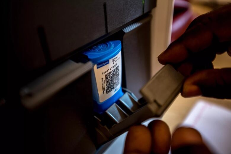 Close-up of cartridge being loaded into machine. 