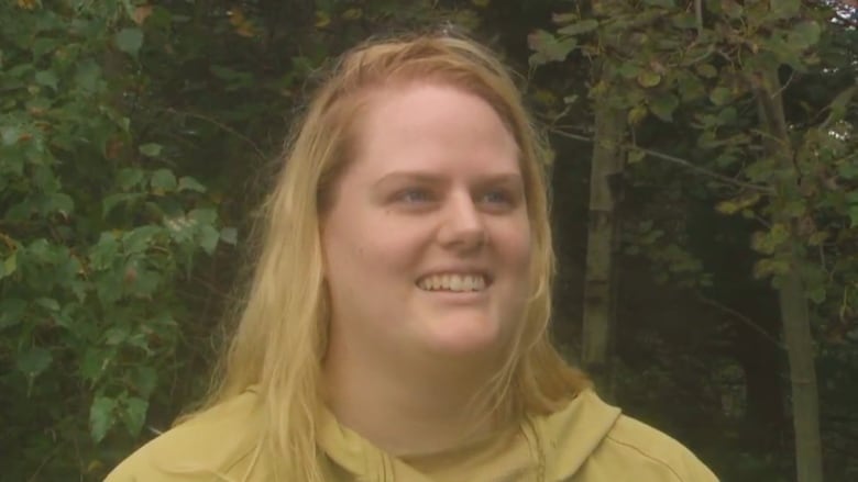 A smiling woman with blond hair seen from the shoulders up