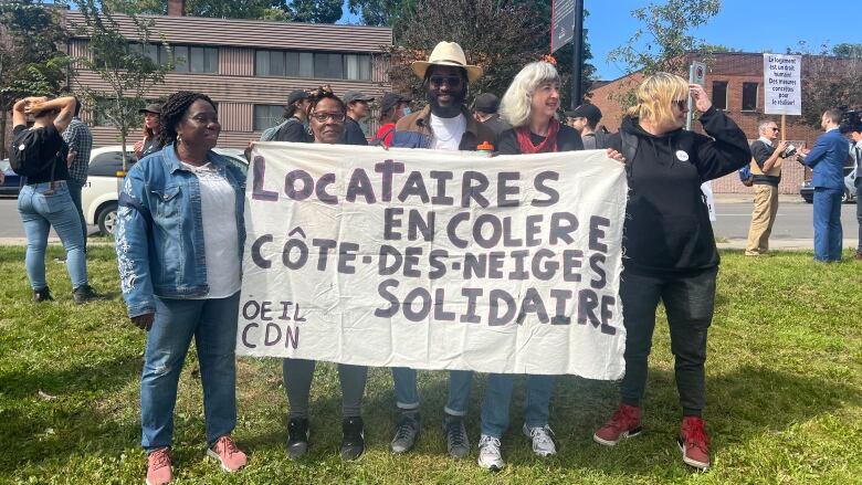 people holding a protest banner that says 