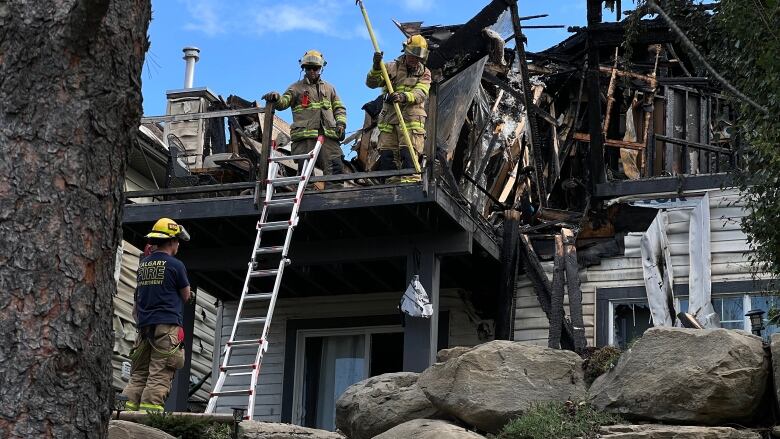 A damaged home with firefighters.