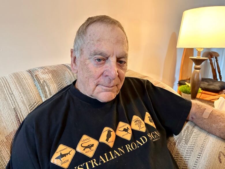 A senior age man sitting on a couch.