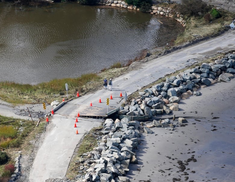 A damaged bridge with rocks on it.