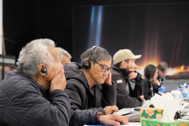 A row of people sit at a table.