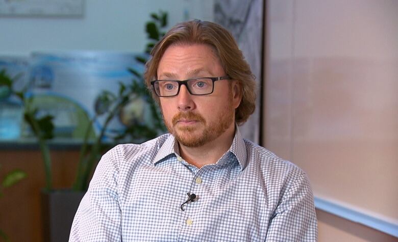 A portrait of of a man with a beard and glasses. 