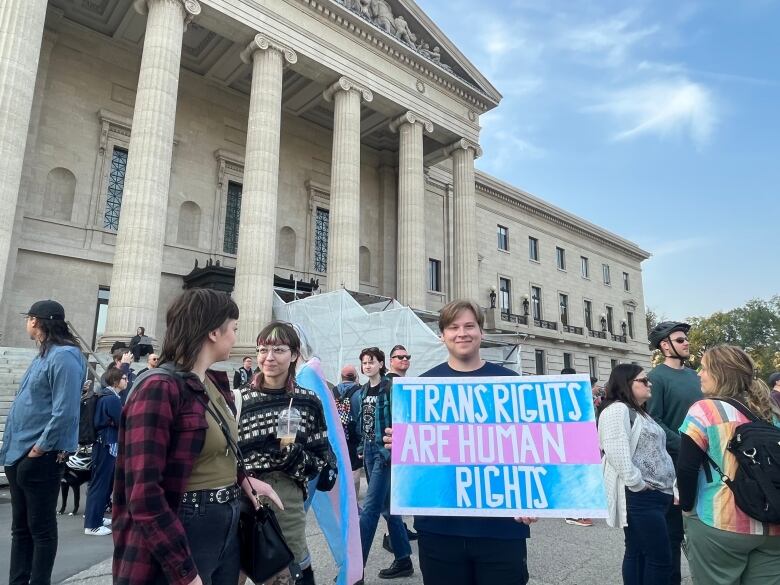 A person holds up a sign that reads 'Trans rights are human rights.'