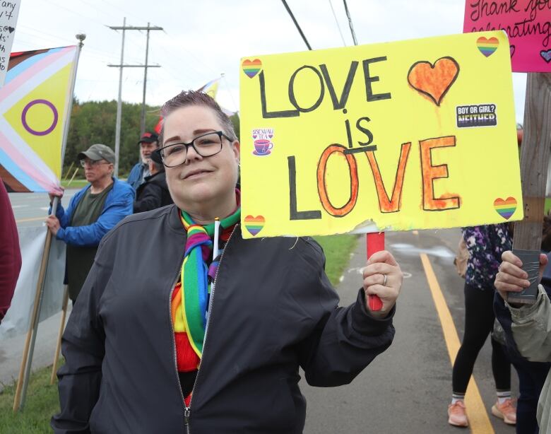 Diana Wright holds sign saying 